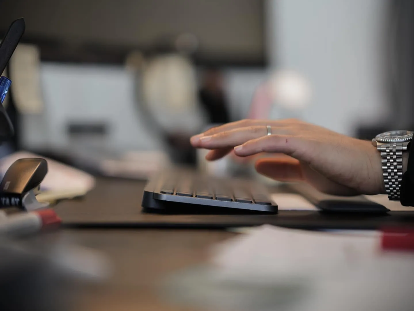 Hand an einer Computertastatur auf einem Schreibtisch — viele Ummeldungen lassen sich online erledigen