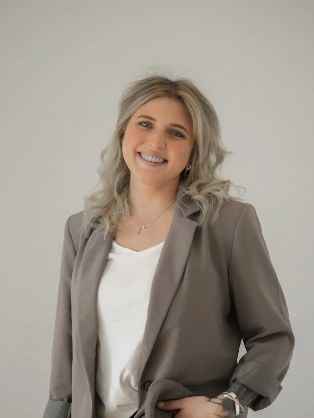 Porträt von Milena Seubert im grauen Blazer, lächelnd.